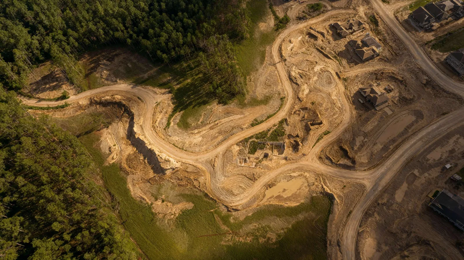 Vista aérea institucional de terraplenagem e abertura de vias em uma área em urbanização, sem identificação de projeto